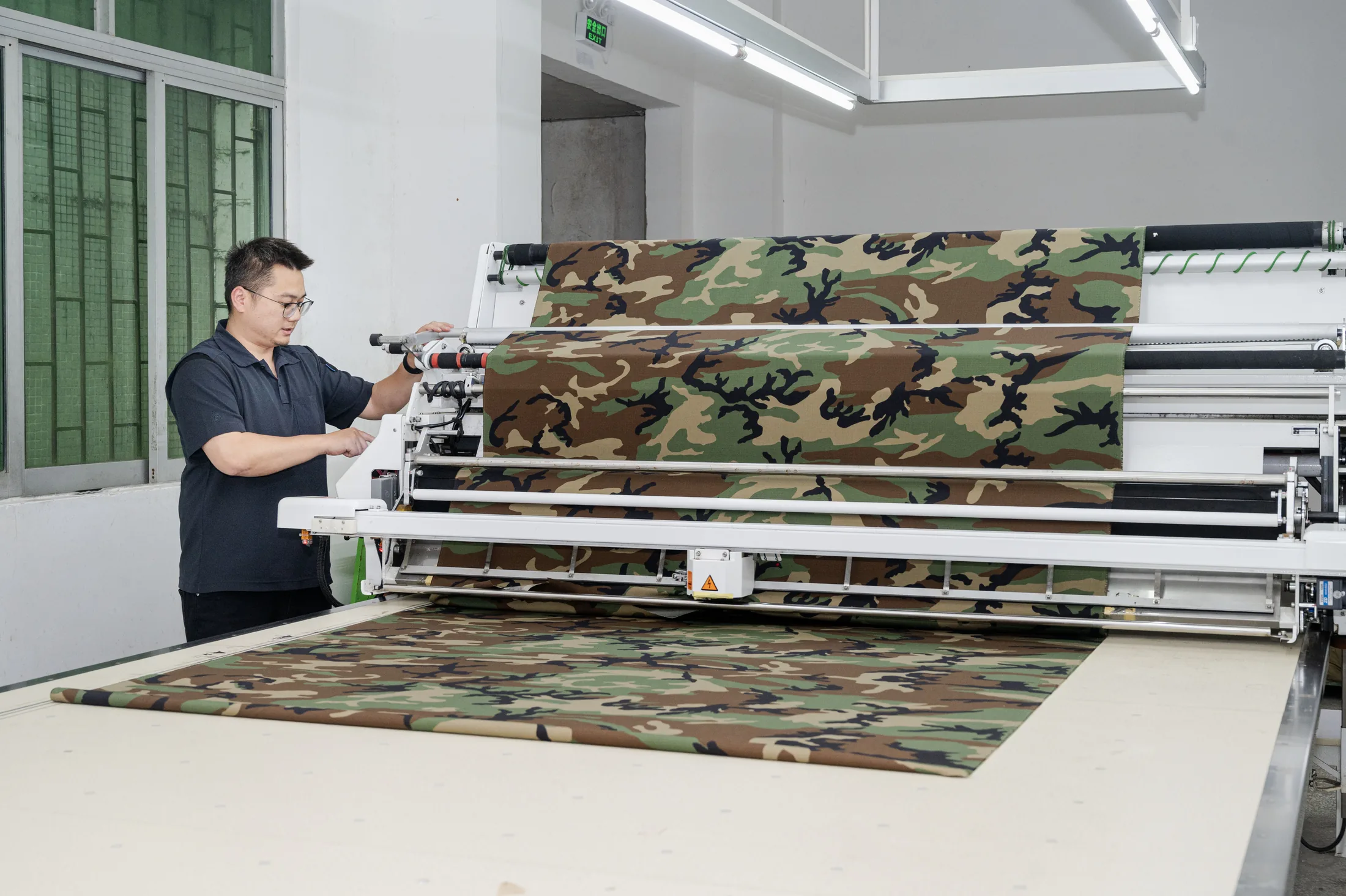 Camouflage fabric being prepared on industrial equipment